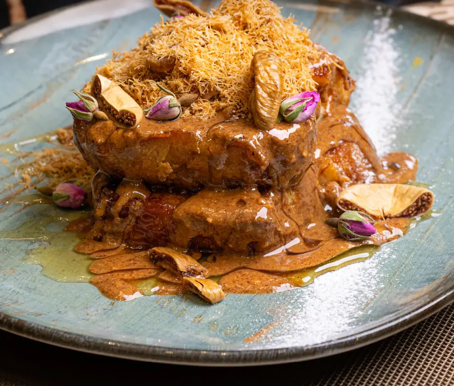 Pain perdu à l'amlou et au miel, coiffé de kounafa dorée, figues séchées et boutons de rose