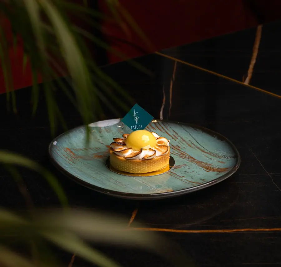 Tartelette au citron meringuée, dôme de curd brillant, losange céladon La Fuga, plat céladon sur marbre noir