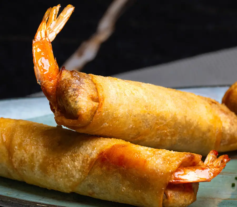 Nems dorés aux crevettes, queues laquées apparentes, sur plat céladon