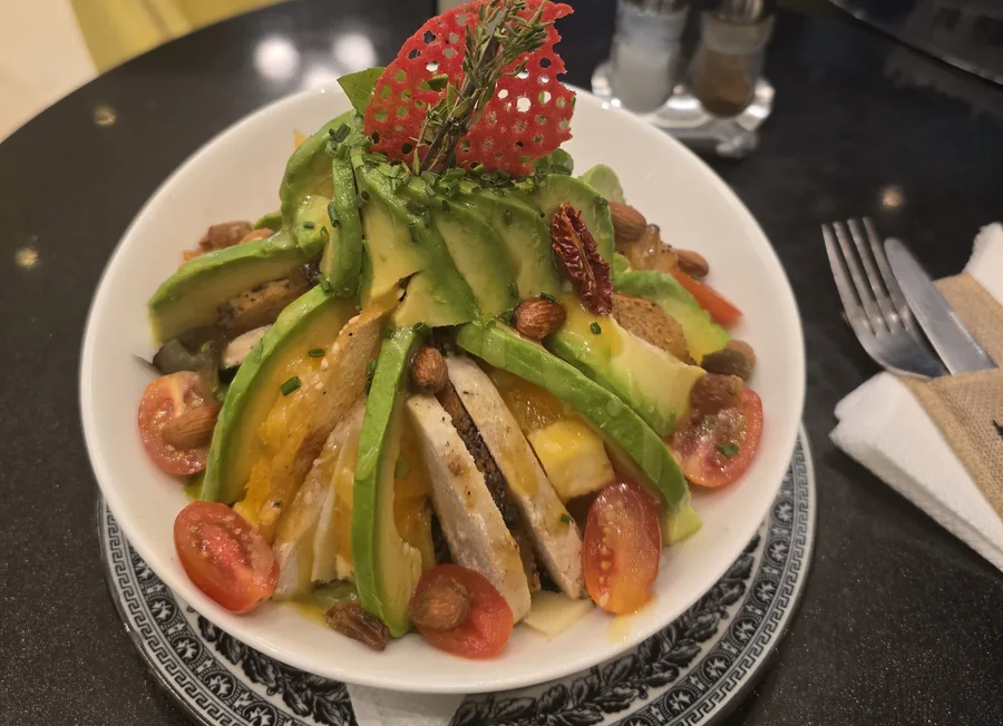 Salade à l'avocat et au poulet grillé, tomates cerises, amandes, tuile rouge